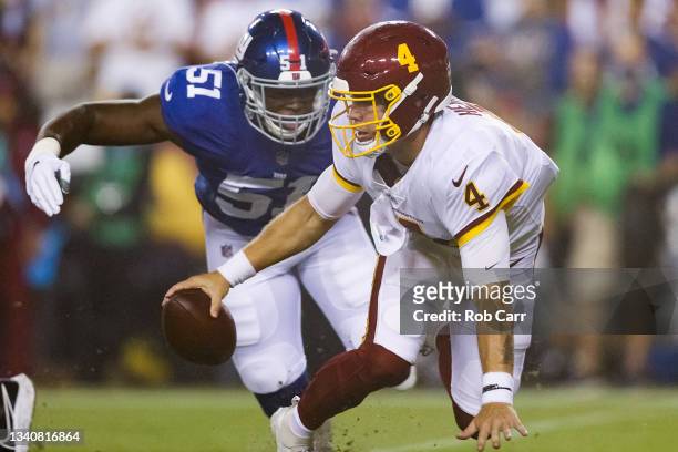 Taylor Heinicke of the Washington Football Team scrambles from defender Azeez Ojulari of the New York Giants during the first quarter at FedExField...