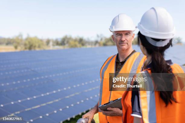 ingenieros que trabajan juntos en la instalación de granjas solares - farm australia combine fotografías e imágenes de stock