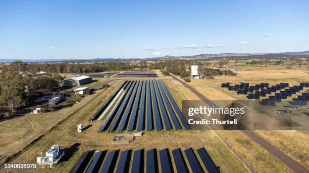 drone view of photovoltaic solar panels in field on solar farm - rural queensland stock pictures, royalty-free photos & images