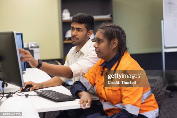 ingeniero y aprendiz trabajando juntos en la oficina - grupos minoritarios fotografías e imágenes de stock