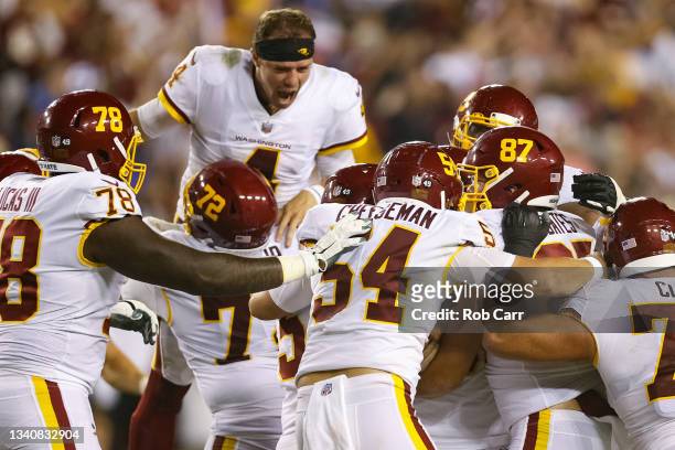 Taylor Heinicke and the Washington Football Team celebrate a 30-29 win over the New York Giants at FedExField on September 16, 2021 in Landover,...