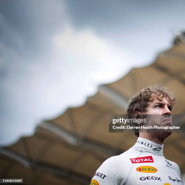 German Red Bull Racing Formula One team racing driver Sebastian Vettel with an angry facial expression standing on the starting grid in front of the...