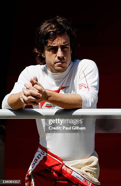 Fernando Alonso of Spain and Ferrari is seen on the pitwall after retiring early with an engine problem during practice for the Brazilian Formula One...