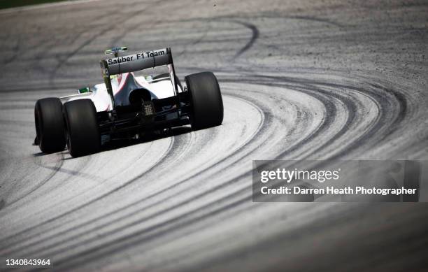 Mexican Sauber Formula One team racing driver Sergio 'Checo' Pérez driving his C31 racing car at speed around Turn Five of the circuit alongside...