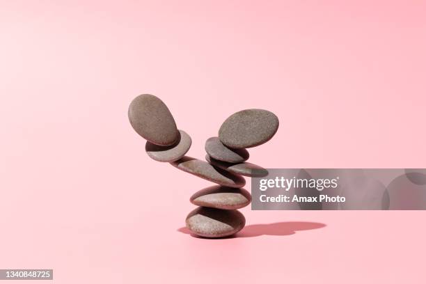 concept of balance of gray stones on a pink background - pedra material de construção imagens e fotografias de stock