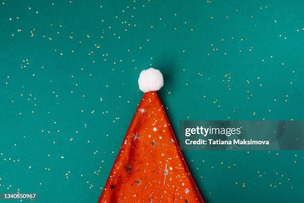 christmas and new year concept. red christmas hat on green background. - röd hatt bildbanksfoton och bilder