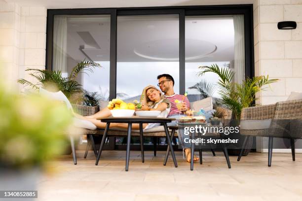 giovane coppia felice che si diverte insieme su un patio. - garden furniture foto e immagini stock