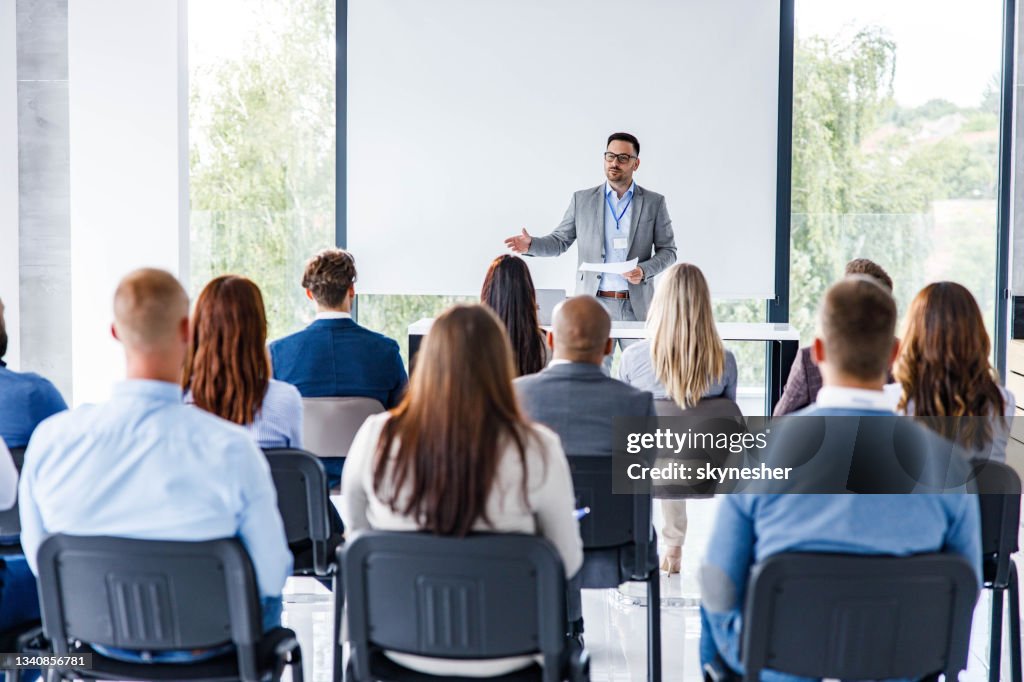 Business leader giving a speech on a seminar in board room.