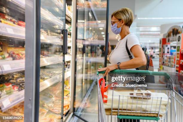 femme faisant ses courses au supermarché - frozen stock photos et images de collection