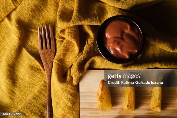 patatas bravas on a wooden plate - patatas chips stock pictures, royalty-free photos & images