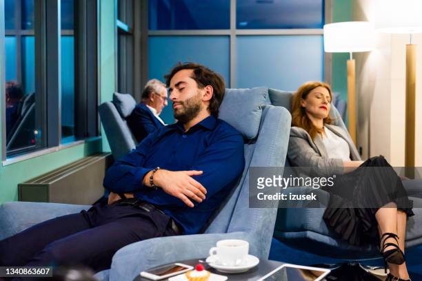 business people napping in the airport vip lounge - business class lounge stock pictures, royalty-free photos & images