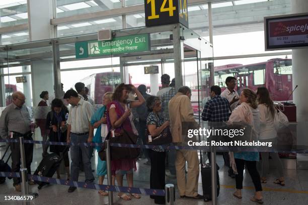 Indian and foreign passengers wait for their flight to Goa October 11, 2011 in the domestic terminal of the Indira Gandhi International Airport in...