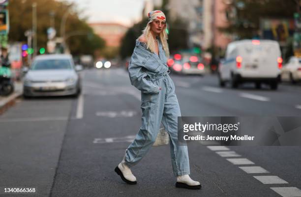 Trixie Giese wearing a jeans jumpsuit, white bag and white boots on September 13, 2021 in Berlin, Germany.