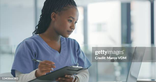 shot of a female nurse filling in a patients chart - medisch dossier stockfoto's en -beelden