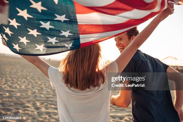 beautiful young couple by the beach - american flag beach stock pictures, royalty-free photos & images