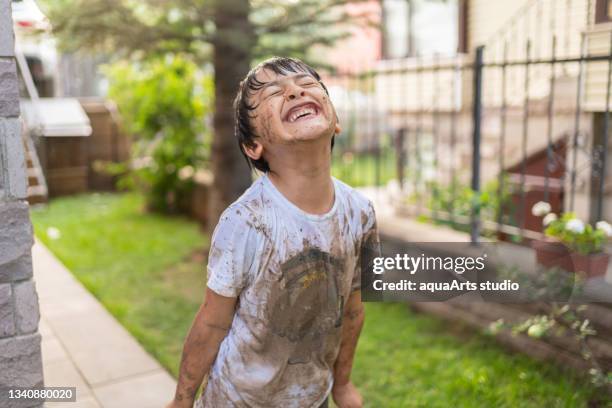 child with dirty clothes i̇n mud - dirty shirt stock pictures, royalty-free photos & images