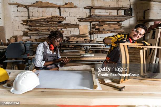 team of professional carpenters working with wood in carpenter's shop. - middle class female stock pictures, royalty-free photos & images