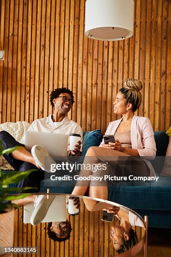 Laughing young businesspeople using different devices during an office break Laughing young businesspeople using different devices during an office break