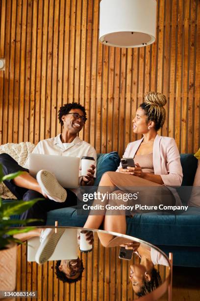 laughing young businesspeople using different devices during an office break - man couch bildbanksfoton och bilder