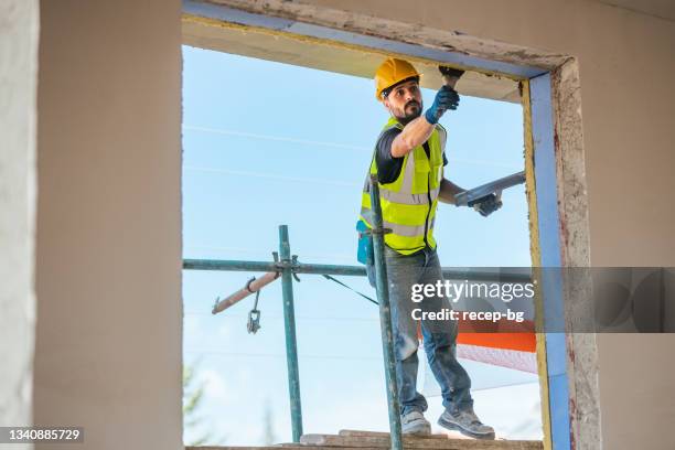 construction worker applying plaster on building facade - applying plaster stock pictures, royalty-free photos & images