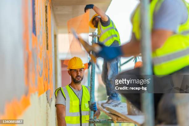 construction workers applying plaster on building facade - applying plaster stock pictures, royalty-free photos & images
