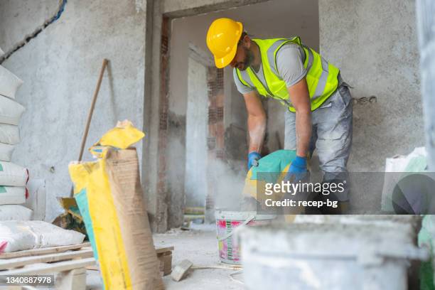 construction worker mixing grout - plasterer stock pictures, royalty-free photos & images