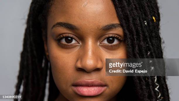 crop ethnic model with brown eyes on gray background - woman portrait skin stockfoto's en -beelden