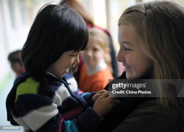 Madelyn Hostetler the biological daughter of American couple Douglas Hostetler and Amanda Hostetler, hugs He Ruichang a disabled Chinese orphan they...