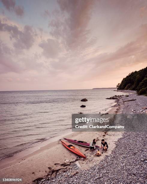 couple relaxing after kayak trip - beach denmark stock pictures, royalty-free photos & images