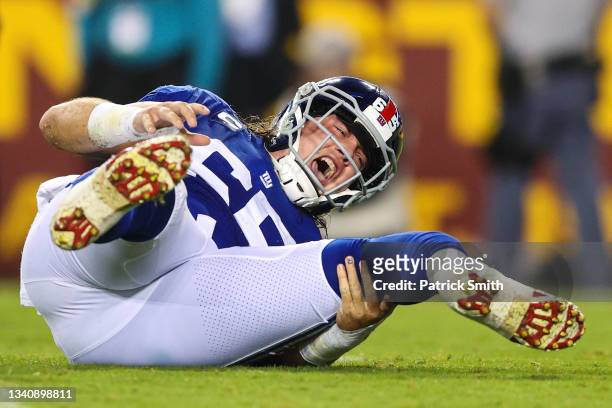 Nick Gates of the New York Giants reacts after injuring his left leg against the Washington Football Team during the first quarter at FedExField on...