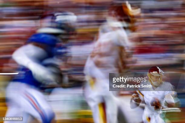 Quarterback Taylor Heinicke of the Washington Football Team scrambles with the ball as he looks to make a pass against the New York Giants during the...