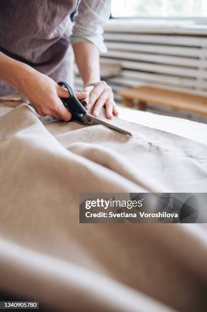 the process of cutting linen canvas by a seamstress. - seam stockfoto's en -beelden