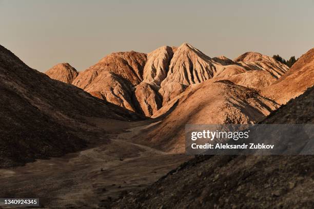 ural apocalyptic surreal unusual landscape, similar to the surface of the planet mars. frozen red-brown surface of chernozem. barren, cracked and scorched earth and soil. the concept of global warming. refractory clay quarries. textured background. - mountain range 個照片及圖片檔