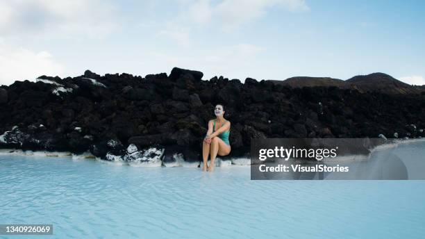 young woman enjoying a day in thermal spa pool with turquoise water in iceland - lagoon stock pictures, royalty-free photos & images