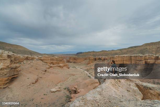 man sitting in canyon in kazakhstan - kazakhstan nature stock pictures, royalty-free photos & images