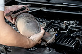 Close up old catalytic converter in hand Technician remove from engine gasoline car dust clogged condition on filter in service concept