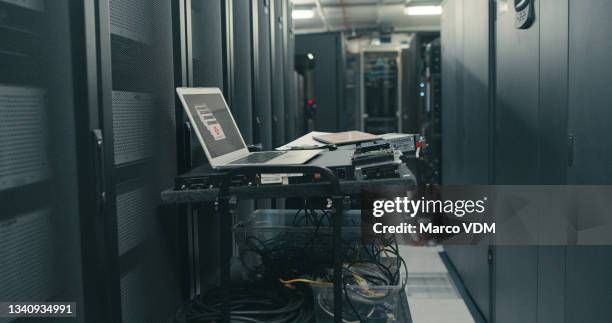 shot of a laptop in an empty server room - computer repair background stock pictures, royalty-free photos & images