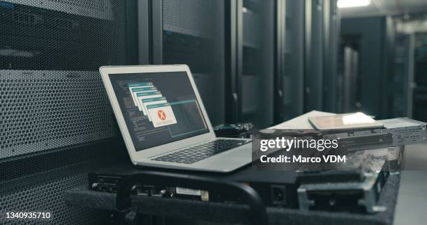 shot of a laptop with an error message on the screen in an empty server room - hard drive stockfoto's en -beelden