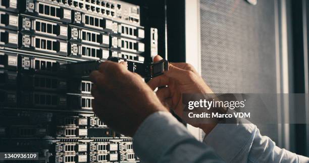 shot of a man inspecting a hard drive in a data centre - removing stock pictures, royalty-free photos & images