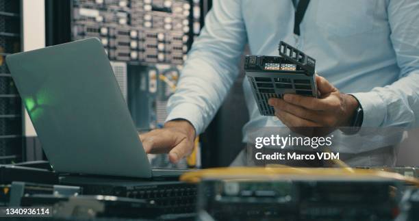 shot of a man using a laptop while working in a data centre - computer hardware engineer stock pictures, royalty-free photos & images