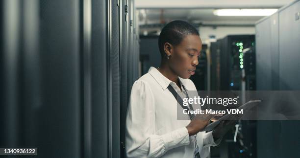 shot of a young woman using a digital tablet while working in a data centre - network security stockfoto's en -beelden