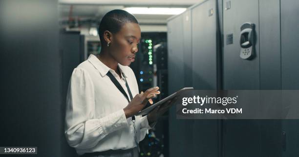 shot of a young woman using a digital tablet while working in a data centre - security 個照片及圖片檔