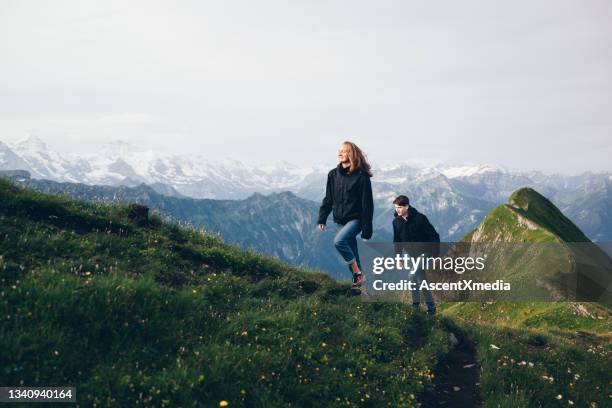 friends hike up mountain ridge in the morning - switzerland mountain stock pictures, royalty-free photos & images