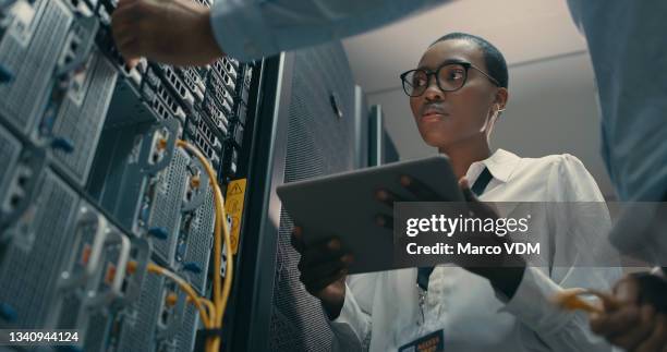 aufnahme eines mannes und einer frau mit einem digitalen tablet bei der arbeit in einem rechenzentrum - business security stock-fotos und bilder