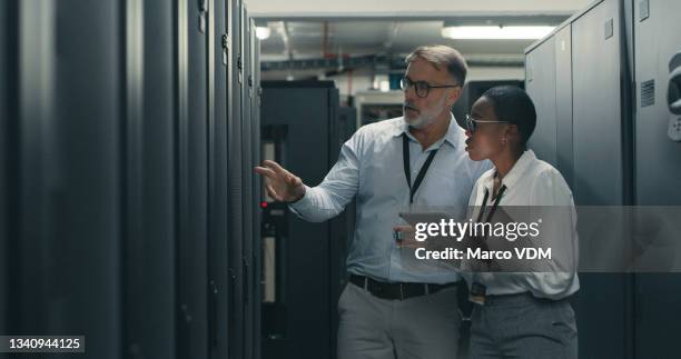 shot of a man and woman using a digital tablet while working in a data centre - 保安 個照片及圖片檔