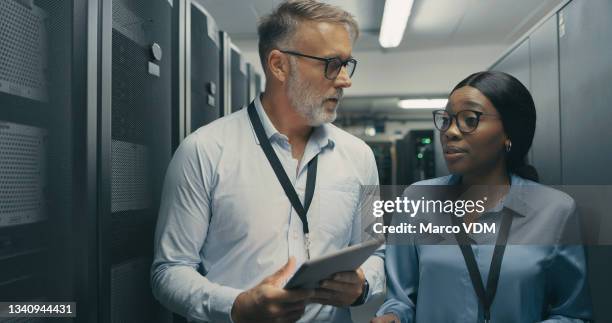 shot of a man and woman using a digital tablet while working in a data centre - database server stock pictures, royalty-free photos & images
