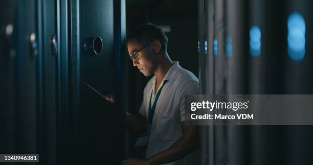 shot of a young man using a digital tablet while working in a data centre - low code stock pictures, royalty-free photos & images