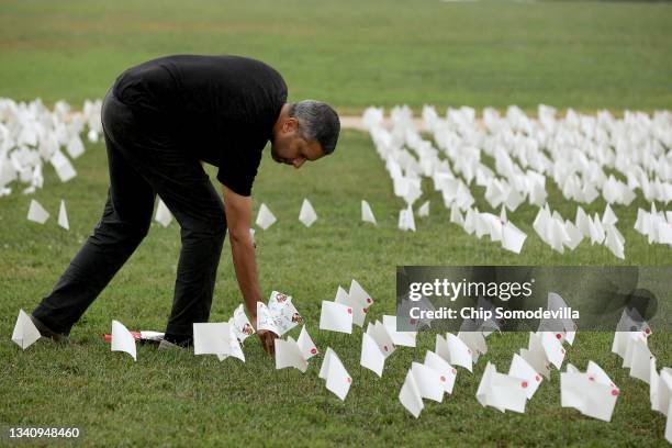 Dr. Debjeet Sarkar places 63 flags into the ground to represent the patients he cared for who died from the coronavirus as part of the 'In America:...