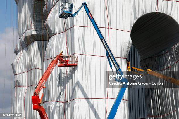 Workers prepare the "L'Arc de Triomphe, Wrapped" art installation designed by the late artist Christo at the Arc de Triomphe monument on September...