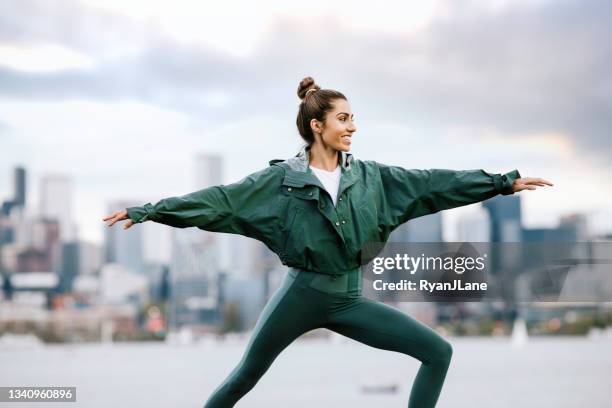 woman stretching and meditating by seattle waterfront - seattle city life stock pictures, royalty-free photos & images